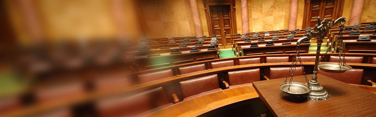 Sala de audiencias con una balanza de bronce sobre el estrado